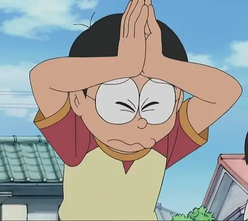 Nobita đứng giữa sân trống ba ống xi măng, áo vàng nổi bật và nét mặt ngơ ngác như vừa bị Chaien gọi tên trong định mệnh