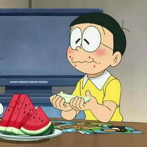 Meme chế Nobita ngồi ăn dưa hấu trên bàn thấp, má phồng và ánh mắt thỏa mãn làm cảnh sinh hoạt đời thường hóa thành hình vui Nobita