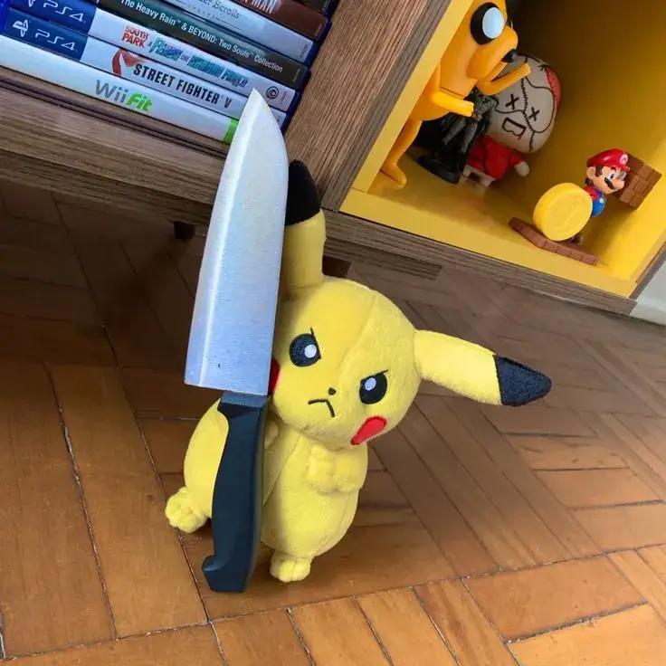 Meme Pikachu cầm dao đứng trên sàn gỗ, đôi tai đen dựng lệch và ánh nhìn nhỏ xíu tạo cảm giác lầy lội