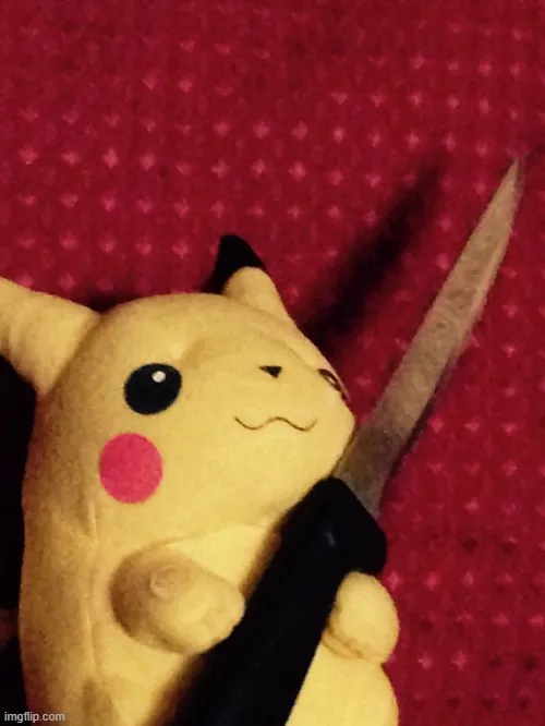 Khoảnh khắc thú bông Pikachu nằm trên vải đỏ, tay cầm dao nhựa khiến vẻ ngoài mềm mại bỗng hóa nghịch ngợm