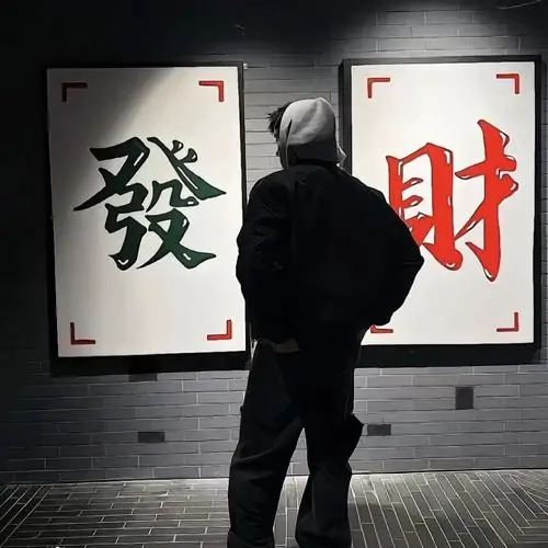 Người đeo kính đen tựa vào tường bê tông, áo khoác da bắt sáng nhẹ và bố cục nghiêng làm ảnh trông gọn mà sắc