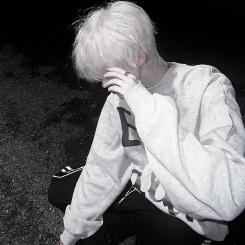 Chàng trai quay lưng trên sân thượng lúc trời chạng vạng, phông nền thành phố mờ giúp dáng áo hoodie đen nổi bật
