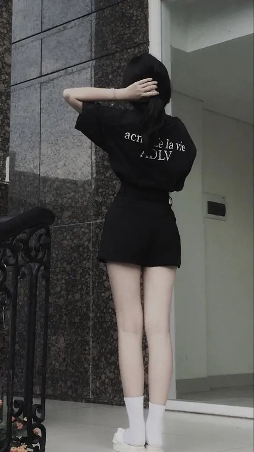 Cầu thang tối phía sau giúp ảnh hot girl thả dáng trông nổi hơn, cô gái mặc set đen, đứng quay lưng đầy gọn gàng