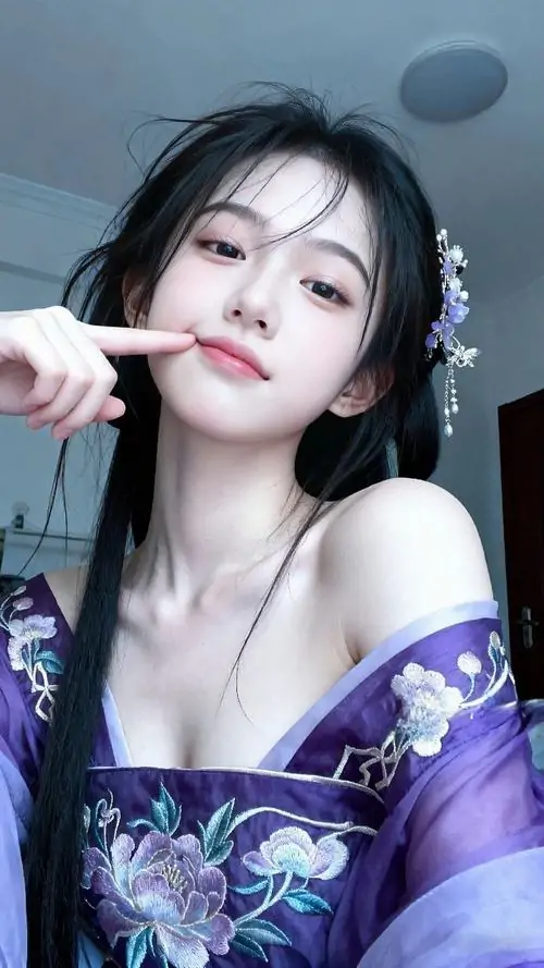 Một bàn tay đưa gần ống kính làm khung hình vui mắt, cô gái tóc dài đội mũ, mặc áo sáng và nhìn máy ảnh đầy tinh nghịch