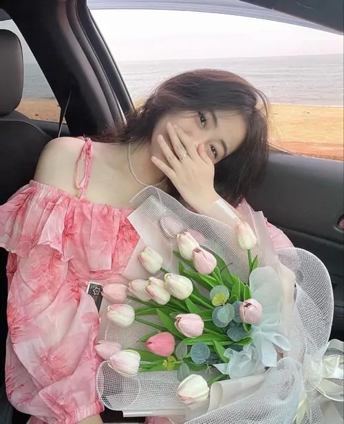 Vườn hoa tím làm nền cho ảnh cô gái ngọt ngào mặc váy trắng, cô ôm bó hoa nhỏ và mỉm cười trong trẻo