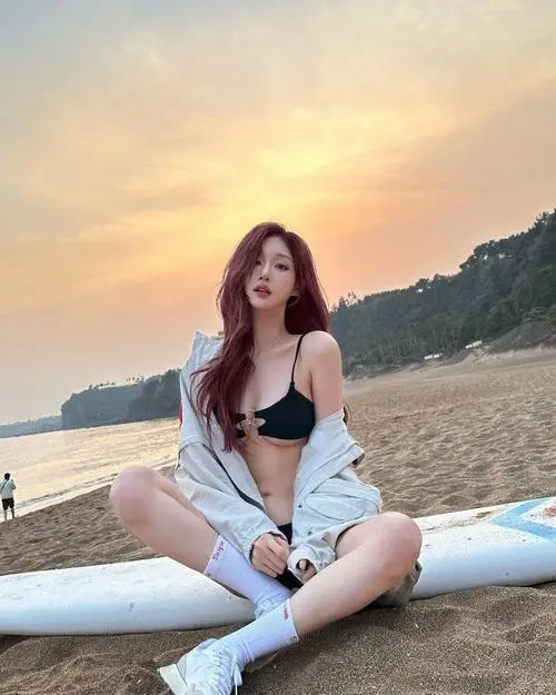 Ánh chiều trên bãi biển ôm lấy hình hot girl vóc dáng đẹp đang ngồi thả lỏng, áo khoác trắng và nụ cười nhẹ nhàng
