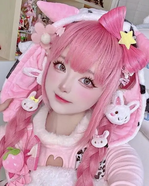 Mái tóc hồng pastel nổi bật quanh gương mặt trắng sáng, cô nàng cosplay nhìn thẳng vào máy ảnh với biểu cảm trong veo