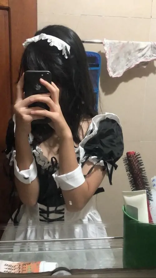 Qua gương soi, người mẫu che mặt bằng điện thoại, váy hầu gái đen trắng ôm vừa người và cổ tay ren nhìn rất chỉn chu