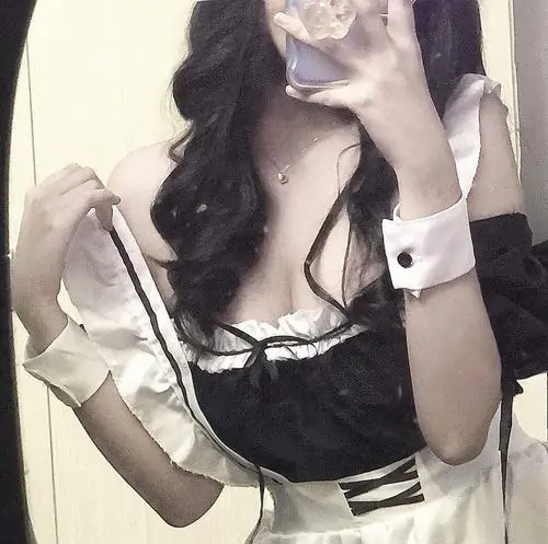 Cận cảnh hình gái xinh phong cách maid với mái tóc đen dài che nhẹ gương mặt, bộ váy trắng đen ôm gọn tạo nét mềm mại