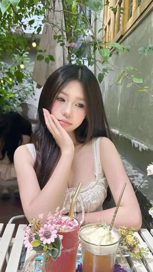 Chiếc kẹp nơ hồng trên tóc giúp ảnh thiếu nữ dễ thương thêm xinh xắn, cô gái mặc váy trắng và nhìn nghiêng thật mềm