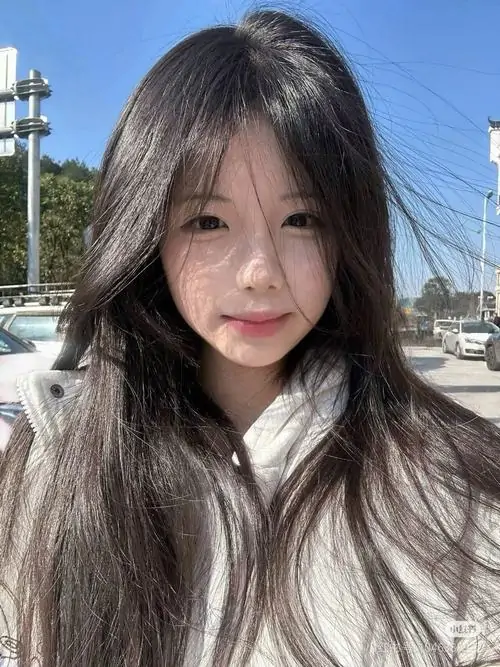 Hoàng hôn vàng trên biển ôm lấy cô gái cầm bó hoa, váy sáng nhẹ và nụ cười rạng rỡ tạo cảm giác thanh xuân