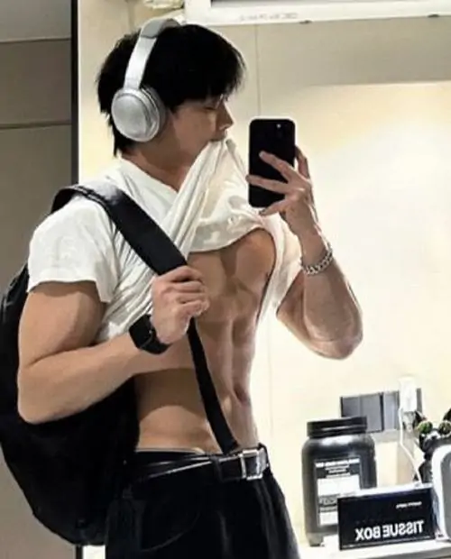 Anh trai co bap tap luyen truoc guong voi ao tank top toc gon va dang dung tu tin day suc hut 10