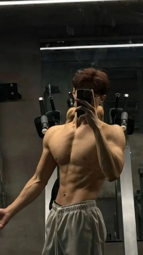 Anh trai co bap tap luyen truoc guong voi ao tank top toc gon va dang dung tu tin day suc hut 3