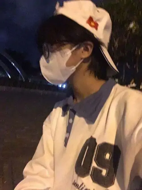 Mũ lưỡi trai sáng màu cùng khẩu trang trắng che nửa mặt, cậu bạn hoodie be đứng ngoài tối với dáng vẻ yên lặng