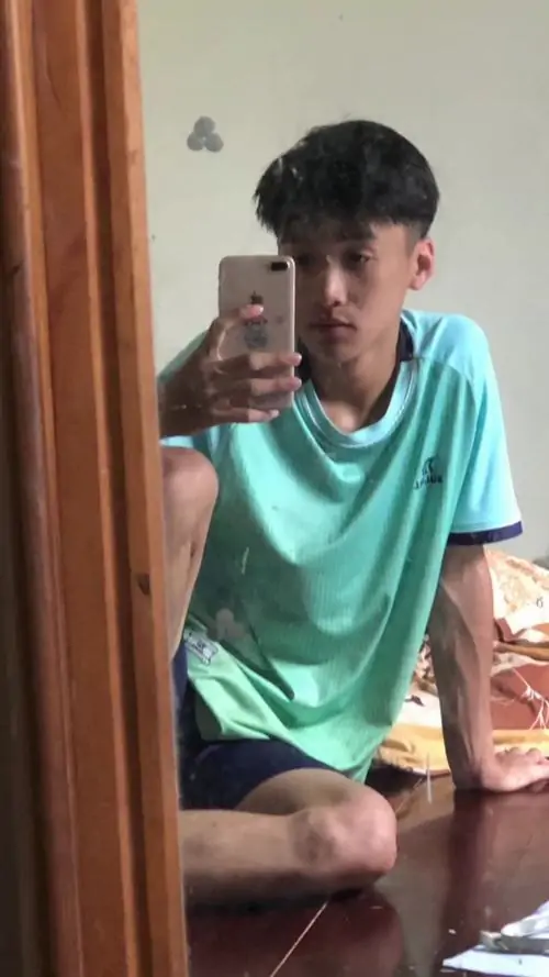Áo xanh ngọc làm cậu bạn 2012 ngồi selfie trước gương trông tươi hơn, tóc cắt sát hai bên và ánh mắt hiền