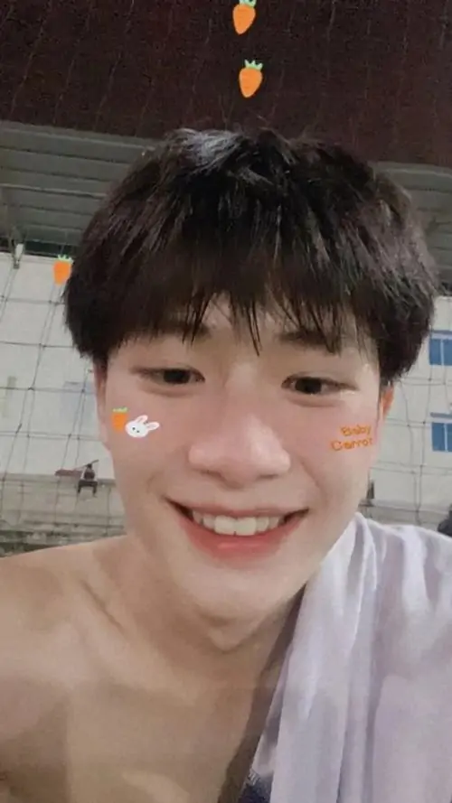 Cậu bé Việt Nam với nụ cười rạng rỡ và hai má hồng hào đang nhìn thẳng vào camera trong không gian ấm áp.