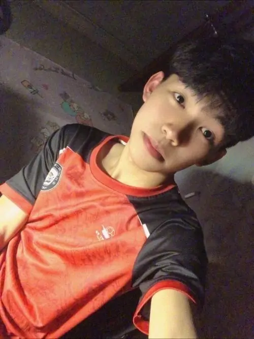 Bạn trẻ mặc áo thể thao đỏ đang giơ tay tạo dáng vui vẻ trong gương.