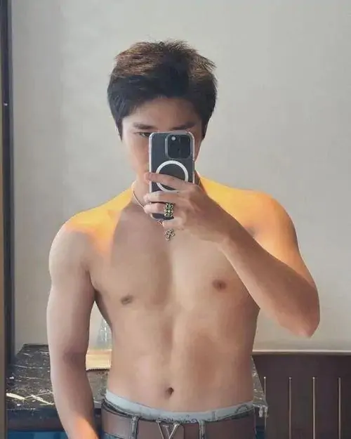 Trước gương, ảnh nam thần cơ bắp Việt ghi lại chàng trai đội mũ đen, thân trên trần, cơ bụng săn và tay cầm điện thoại