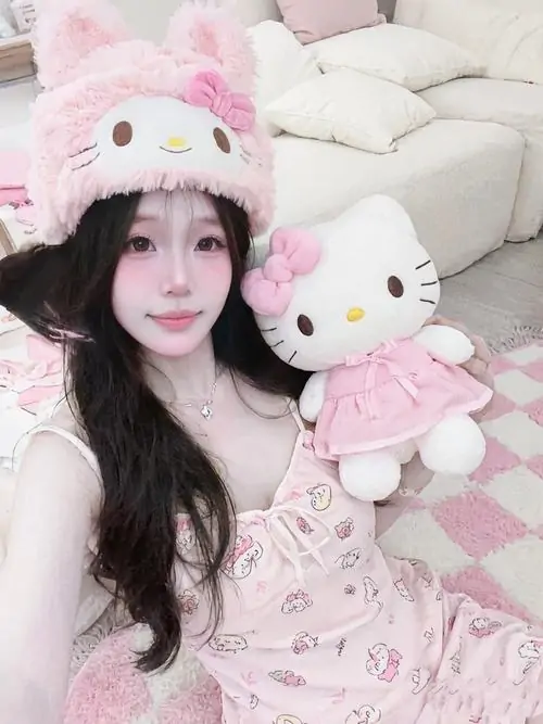 Căn phòng trắng cùng thú bông lớn tạo cảm giác ấm áp, cô nàng mặc đồ hồng nhạt ngồi thư thái và nhìn dịu dàng