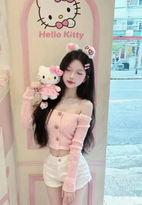 Bên mô hình Hello Kitty hồng, hình quý cô diện đồ hồng khoe dáng trong outfit hai mảnh với nụ cười tươi tắn
