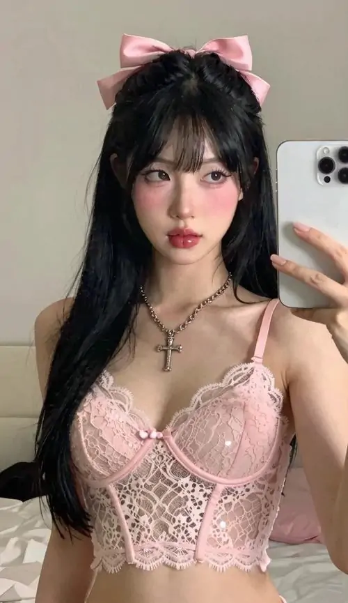 Góc selfie trước gương ghi lại hình nữ sinh áo hồng, áo corset ren pastel tôn dáng và mái tóc đen buông dài