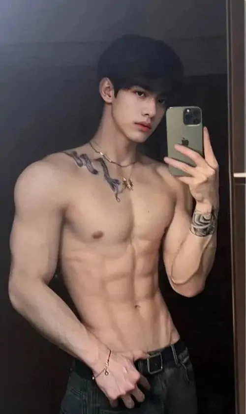 Nam mẫu chụp gương cận thân, áo đen kéo cao, quần thể thao rộng và vùng bụng nổi khối rõ trong phòng ngủ