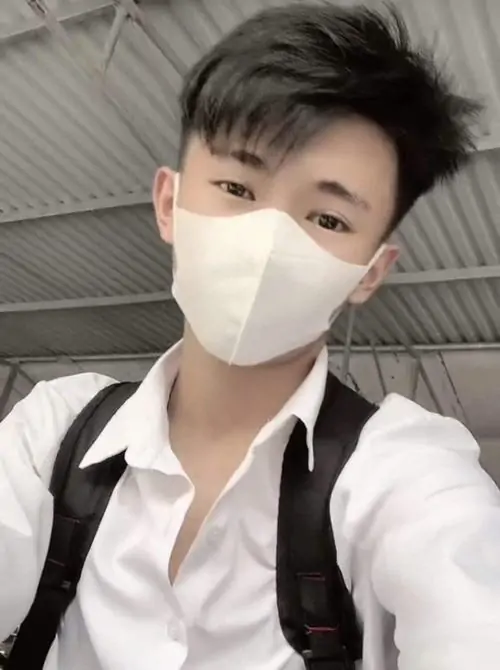 Khẩu trang trắng cùng áo sơ mi học sinh giúp cậu bạn đeo balo trông gọn gàng, mái tóc vuốt cao và dáng selfie tự tin