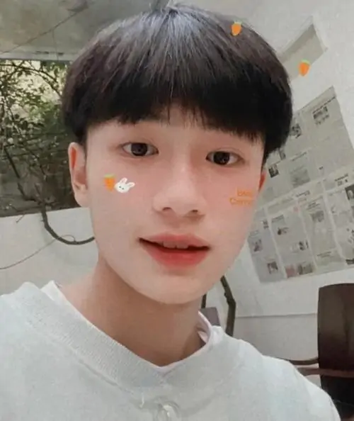 Chàng trai tóc dài đen đang selfie trong gương với ánh mắt sâu.
