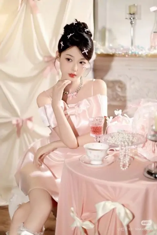 Cúc áo ngọc trai trên váy hồng khiến cô nàng trông thanh lịch, ánh sáng studio ấm làm làn da thêm rạng rỡ