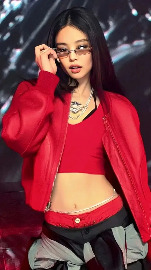 Trong outfit đỏ đen nổi bật, cô gái đeo kính tạo dáng trên ghế, ảnh nhan sắc quốc tế có màu sắc mạnh và phong cách thời thượng