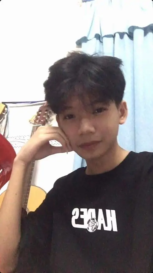Áo khoác đen phối quần sáng tạo vẻ gọn gàng cho bạn nam đứng ngoài hành lang, tay đút túi và ánh mắt bình thản
