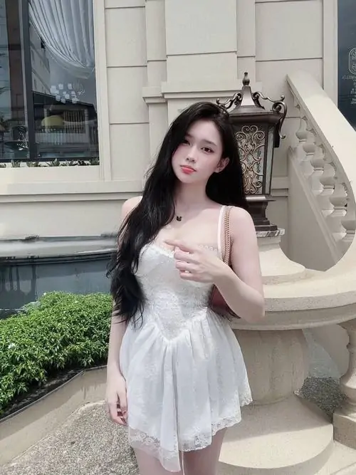 Ánh studio mềm giúp kho ảnh cô nàng mặc đầm trắng ngắn nổi rõ phom váy bồng, bờ vai gọn và dáng ngồi thanh lịch