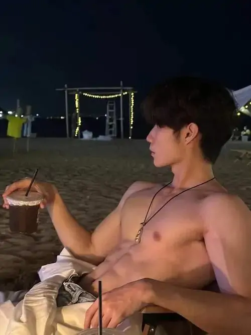 Cận cảnh bụng nghiêng dưới lớp áo đen kéo cao, quần trắng thấp và các múi cơ lộ rõ trong ánh sáng phòng