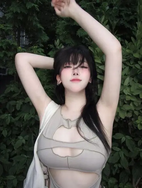 Giữa nền lá tối, hình ảnh mỹ nhân quyến rũ mặc áo trắng mỏng, tóc đen xõa và tạo dáng giơ tay đầy tự tin