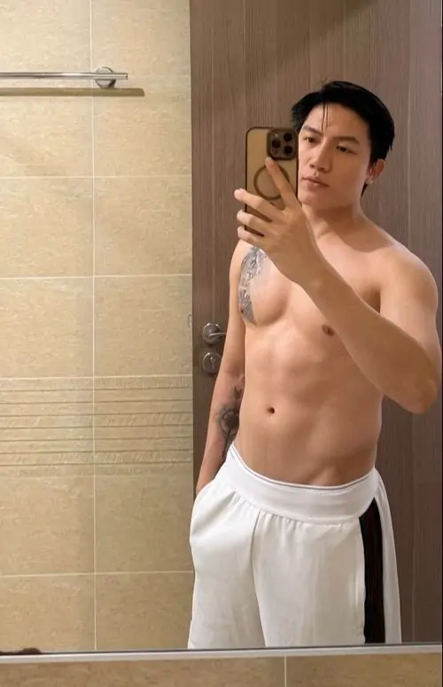Trong phòng tập Elite, chàng trai cầm tạ tay sau buổi siết cơ, áo ba lỗ ôm sát, nét mặt quyết tâm và mồ hôi nhẹ