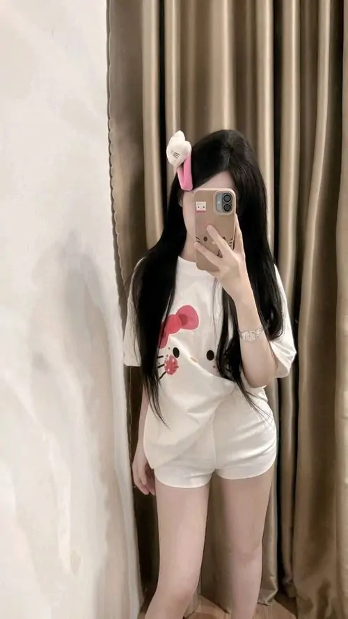 Ống kính bắt sáng tốt trên phố đêm, cô gái mặc áo khoác da và váy ngắn đứng nghiêng, biểu cảm lạnh vừa phải