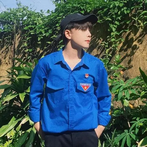 Áo khoác gió đen phối quần trắng giúp bạn nam K12 trông năng động, đứng bên xe đạp với dáng hơi nghiêng