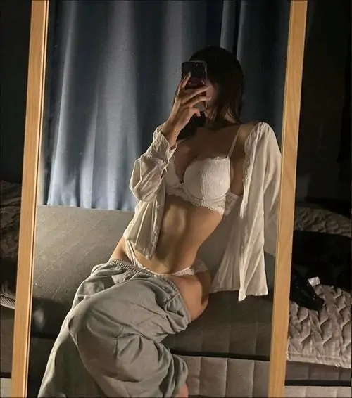 Ánh đèn vàng hắt từ phía sau làm ảnh nữ thần mặc đồ ngủ dễ thương nổi bật với áo choàng trắng và quần xám mềm