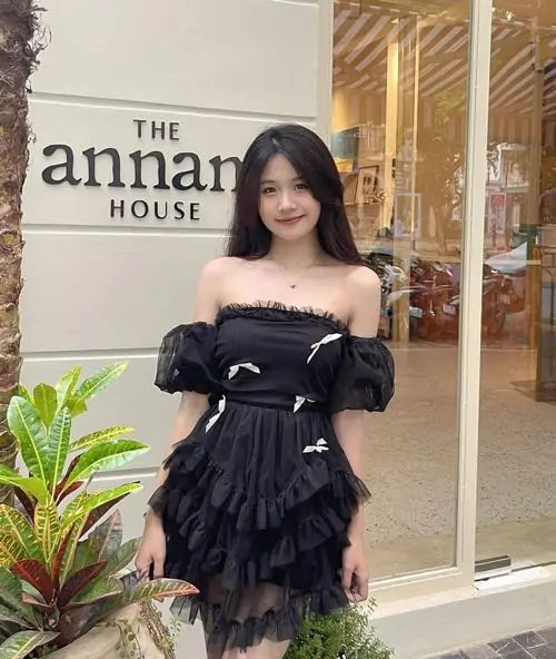 Trước hiên quán, hình ảnh hot girl diện đầm đen ngắn gây chú ý với vai trần, tóc dài và nụ cười nhẹ nhàng