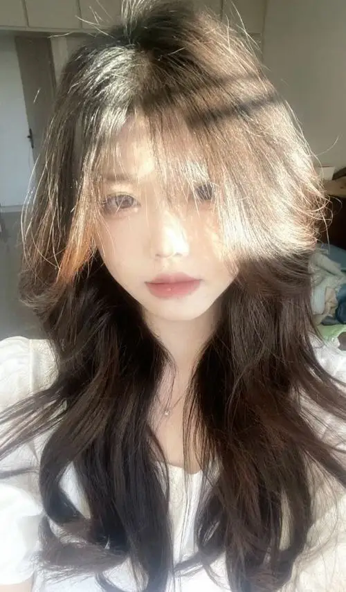 Ảnh thiếu nữ đẹp tỏa sáng dưới ánh nắng ban mai rọi qua tán cây với mái tóc uốn lượn bồng bềnh và đôi mắt to tròn long lanh