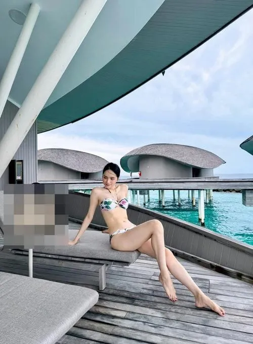 Ở khu hồ bơi hiện đại, ảnh Hương Giang khoe dáng với bikini ghi lại tư thế ngồi duỗi chân, mái tóc buộc gọn và nền trời dịu