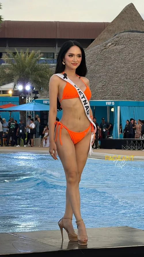 Bên hồ bơi buổi tối, ảnh áo tắm Hương Giang nổi bật với bikini cam, dáng đứng thẳng tự tin và thần thái hoa hậu sang chảnh