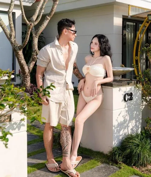 Trong khu nghỉ dưỡng sang trọng, ảnh áo tắm Hương Giang ghi lại dáng đứng cạnh bạn nam, trang phục tông trắng kem hài hòa và nhẹ mắt