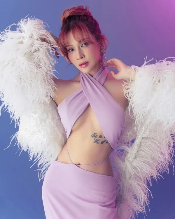 Ánh tím studio ôm lấy ảnh quyến rũ Khả Như trong set hồng pastel, áo lông trắng và dáng đứng nghiêng tạo vẻ nổi bật