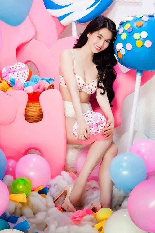 Tông hồng kẹo ngọt bao quanh cô gái trong ảnh áo tắm Ngọc Trinh, phao nhiều màu và dáng ngồi nghiêng tạo nét vui mắt