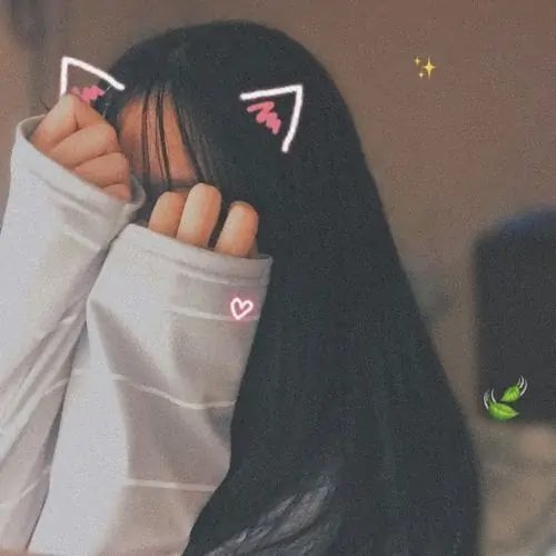 Núp bóng sau những tán lá cọ xanh bạn nữ diện bộ váy maxi hoa nhí nhẹ nhàng dùng chiếc lá lớn che khuất một phần góc mặt nghiêng.
