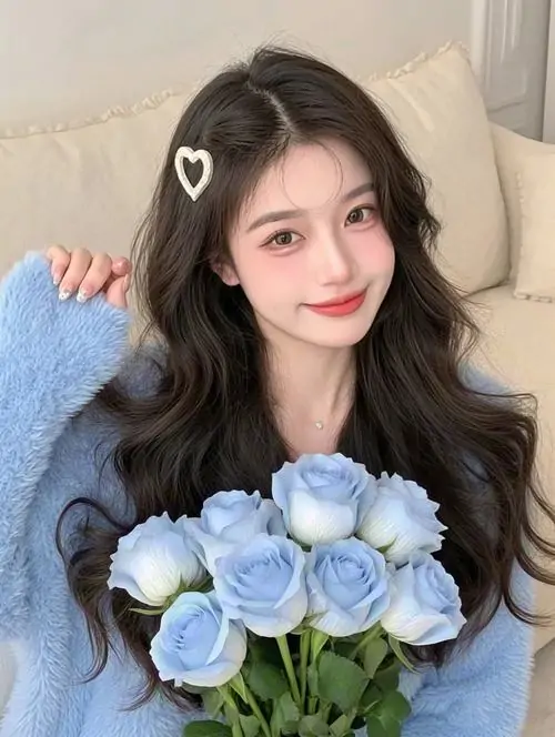 Bó hoa xanh nhạt làm nổi bật cô gái tóc dài nằm trên giường, nụ cười dịu, áo len mềm và gương mặt khả ái