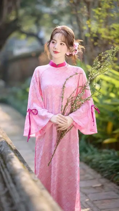 Bên lan can rợp nắng, cô gái áo dài hồng cầm hoa nhỏ, bước đi chậm theo cách đứng chụp ảnh áo dài thướt tha