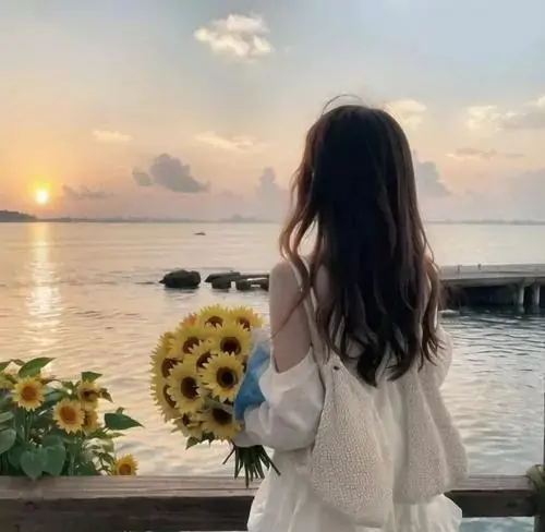 Bó hoa hướng dương rực rỡ trên tay thiếu nữ mặc áo trắng tạo nên một hình nền cô gái quay lưng tràn đầy sức sống bên cầu cảng chiều.