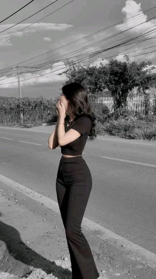 Tông đen trắng khiến cô gái áo croptop tối màu và quần ống loe ôm trông cá tính hơn trên con đường vắng